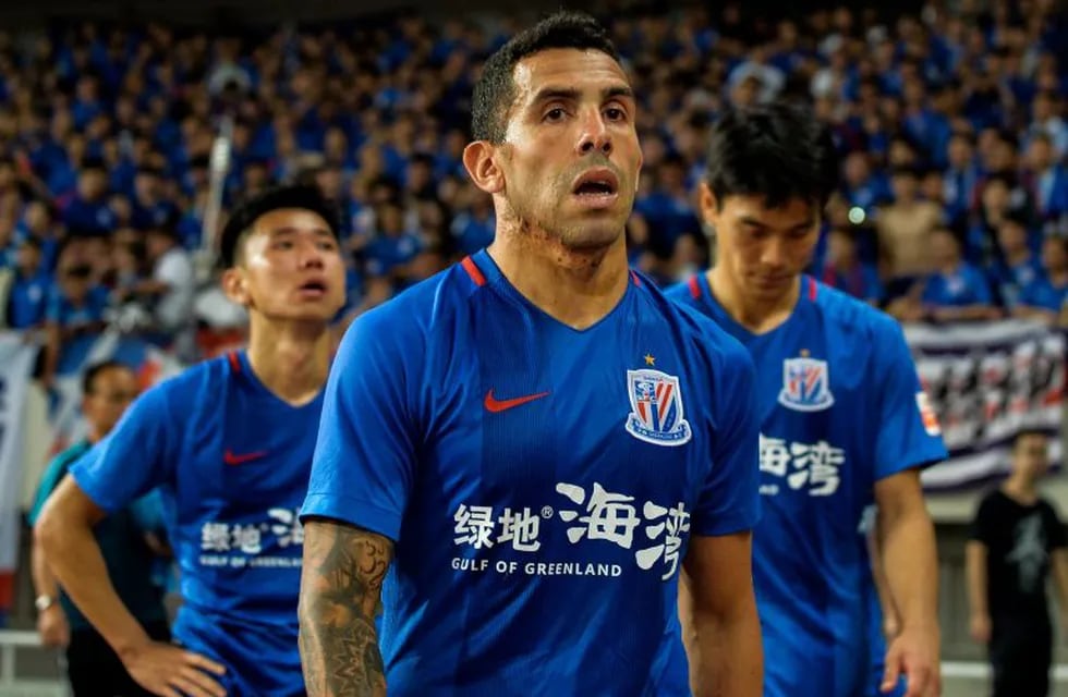 (FILES) This file picture taken on September 16, 2017 shows Shanghai Shenhua's Carlos Tevez walking to the stands after losing the 2017 Chinese Super League football match between Shanghai East Asia (SIPG) FC and Shanghai Shenhua in Shanghai.\nJust eight months after Tevez signed with Shanghai Shenhua, the 33-year-old has become a symbol of Chinese clubs' largesse that the Beijing government hopes will never be repeated. / AFP PHOTO / Chandan KHANNA / TO GO WITH Fbl-Asia-CHN-Shenhua-ARG-Tevez, FOCUS by Peter STEBBINGS