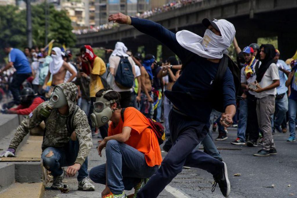 CAR01. CARACAS (VENEZUELA), 06/04/2017 - Un grupo de personas participa en una manifestación de opositores al gobierno de Nicolás Maduro hoy, jueves 6 de abril de 2017, en Caracas (Venezuela). La Policía Nacional Bolivariana (PNB) dispersó hoy con gases lacrimógenos y agua una marcha opositora en Caracas que pretendía llegar hasta la Defensoría del Pueblo para pedir su respaldo al proceso iniciado por el Parlamento contra siete magistrados del Tribunal Supremo de Justicia (TSJ). EFE/CRISTIAN HERNÁNDEZ