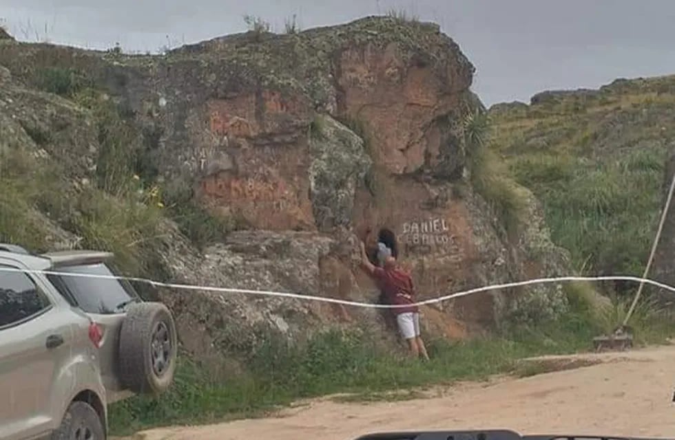 Escrachados pintando las piedras a la vera del camino a las Altas Cumbres.