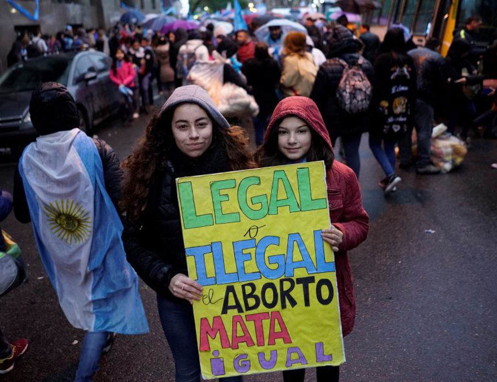 "Legal o ilegal, el aborto mata igual", dice la pancarta de dos jóvenes durante una manifestación en contra de la legalización del aborto.