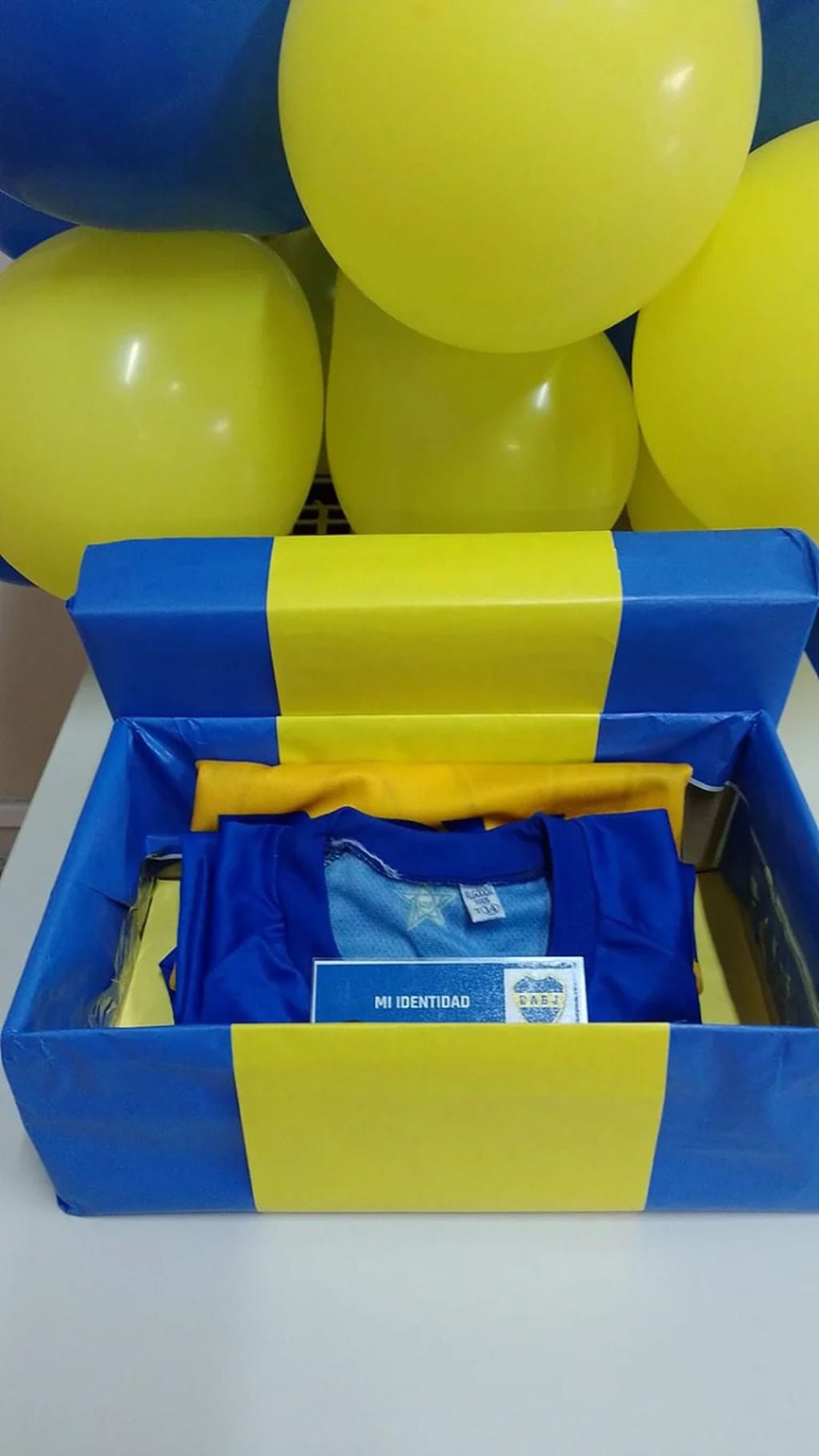 Con una camiseta y globos azules y amarillos, se le comunicó a I. su adopción plena.