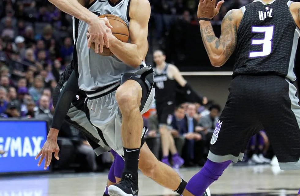 San Antonio Spurs guard Manu Ginobili (20) drives past Sacramento Kings' George Hill (3) during the second half of an NBA basketball game in Sacramento, Calif., Saturday, Dec. 23, 2017. The Spurs won 108-99. (AP Photo/Steve Yeater)