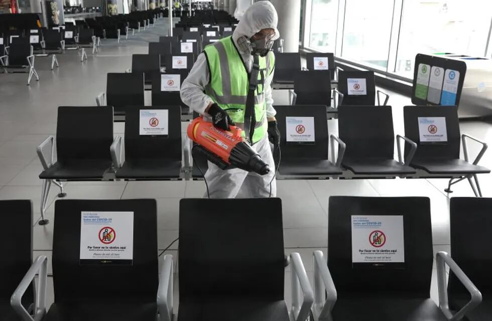 -FOTODELDIA- AME8823. BOGOTÁ (COLOMBIA), 25/06/2020.- Un empleado desinfecta este jueves las sillas de una sala de espera en el Aeropuerto Internacional El Dorado, en Bogotá (Colombia). El aeropuerto El Dorado de Bogotá, tercero más importante de pasajeros en Latinoamérica y primero en transporte de carga, avanza en la implementación de medidas de bioseguridad para proteger a los pasajeros de posibles contagios de coronavirus cuando las aerolíneas regresen a operaciones. EFE/ Carlos Ortega