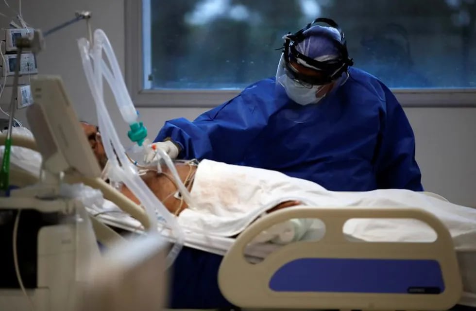 A heath worker attends a patient in an intensive care unit designated for people infected with COVID-19 at a hospital in Buenos Aires, Argentina, Friday, Oct. 2, 2020. (AP Photo/Natacha Pisarenko)   TERAPIA INTENSIVA - CASOS DEL DIA - CORONAVIRUS