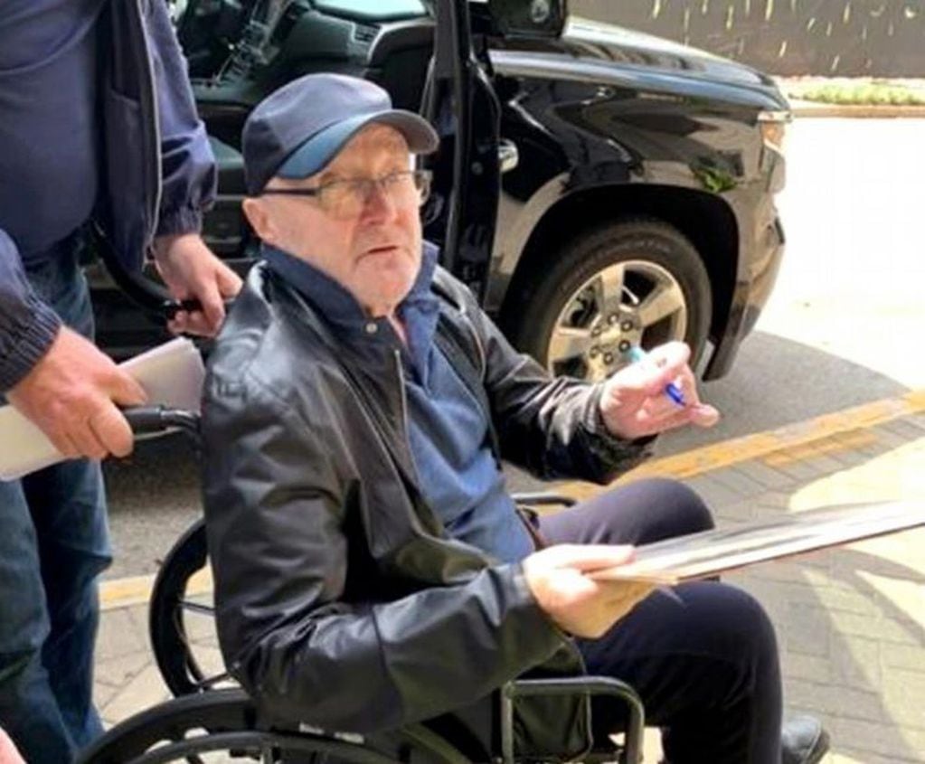 Phil Collins causó preocupación al caerse en un show y terminar en sillas de ruedas