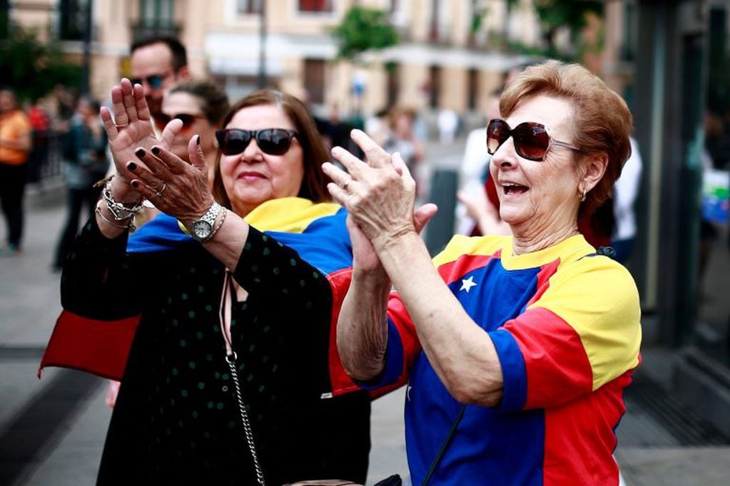 Residentes venezolanos en Madrid aplauden durante una protesta en la Plaza de la Ópera en Madrid contra las elecciones presidenciales venezolanas el 20 de mayo de 2018.