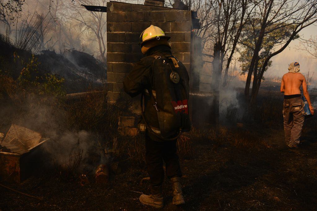 Incendio en una vivienda en Chacras de la Merced. Vecinos combaten las llamas que llegaron a una casa. (José Gabriel Hernández)