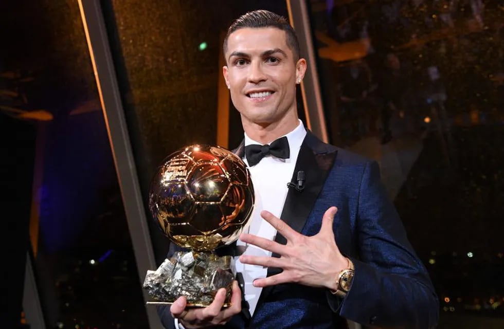 This handout photo released on December 8, 2017 by L'Equipe shows Portugese player Cristiano Ronaldo posing with the 2017 Ballon d'Or France Football trophy in Paris.\nPortuguese star Cristiano Ronaldo won a record-equalling fifth Ballon d'Or (2008, 2013, 2015, 2016 and 2017) award for the year's best player on December 7. The Real Madrid forward's second successive win draws him level alongside Barcelona rival Lionel Messi on five Ballon d'Ors, after beating the Argentinian and Brazilian Neymar. / AFP PHOTO / L'EQUIPE / Franck FAUGERE / RESTRICTED TO EDITORIAL USE - MANDATORY CREDIT \