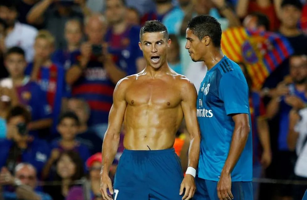 Soccer Football - Barcelona v Real Madrid Spanish Super Cup First Leg - Barcelona, Spain - August 13, 2017   Real Madrid’s Cristiano Ronaldo celebrates scoring their second goal with Raphael Varane and is later booked for removing his shirt   REUTERS/Juan Medina     TPX IMAGES OF THE DAY