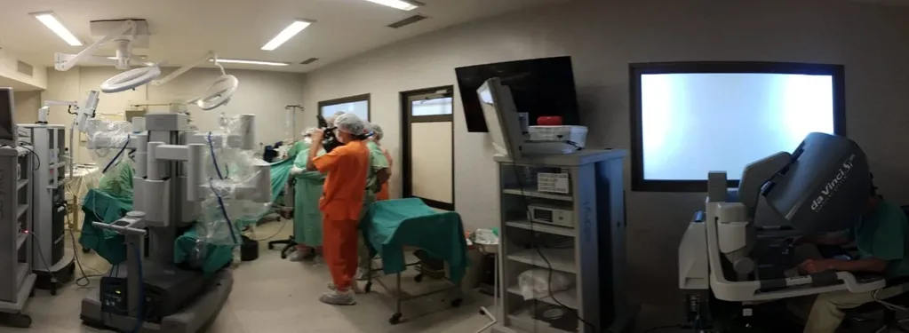 El cirujano (a la derecha) opera de forma remota los brazos del robot.