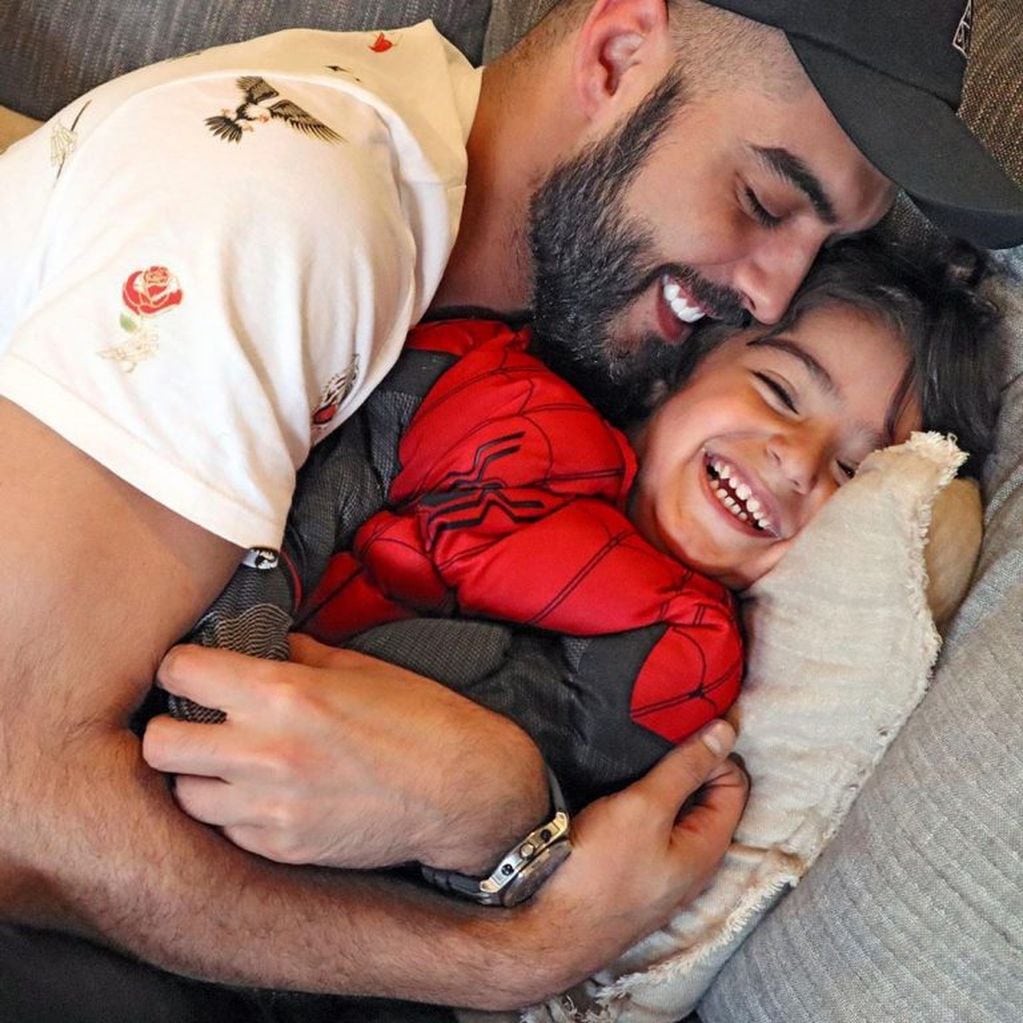 El joven iraquí, considerado el más guapo del mundo, junto a su hijo.