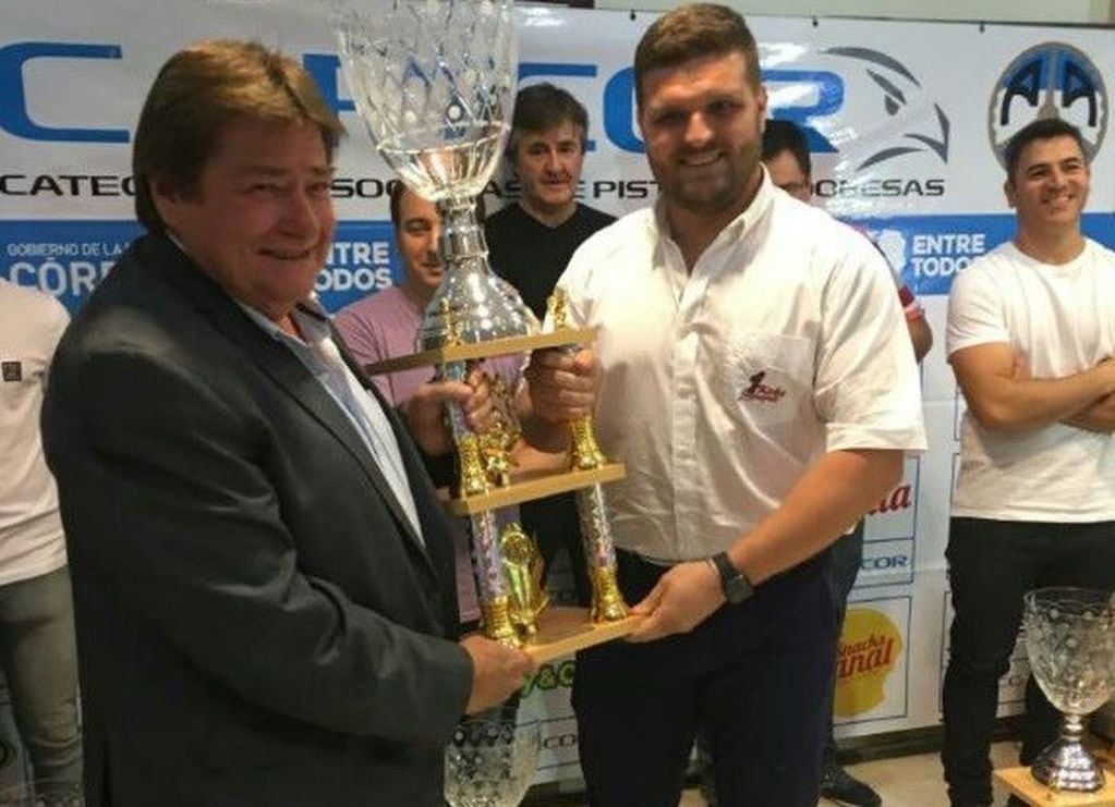El campeón del Turismo Clase 3 1.6, Esequiel Lorenzati (a la derecha) recibe su trofeo de campeón de manos de Girolami, presidente de la FRADC.