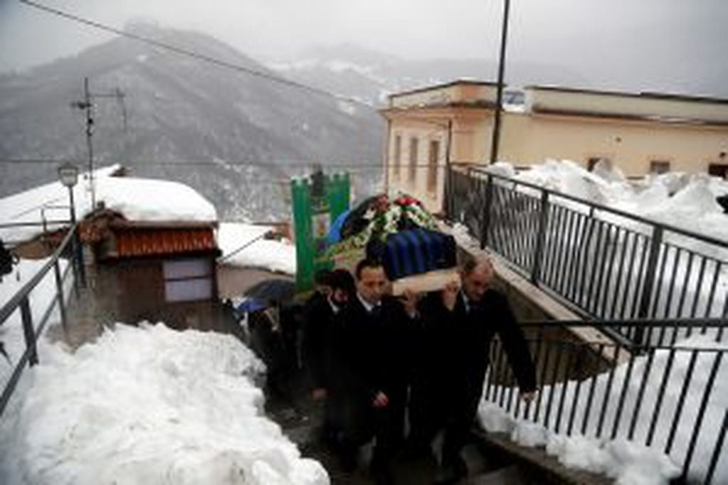 The coffin of Alessandro Giancaterino, one of the victims of the avalanche which buried the Hotel Rigopiano, is shoulder carried prior to the start of the funeral service in Farindola, central Italy,Tuesday, Jan. 24, 2017. The death toll from an avalanche