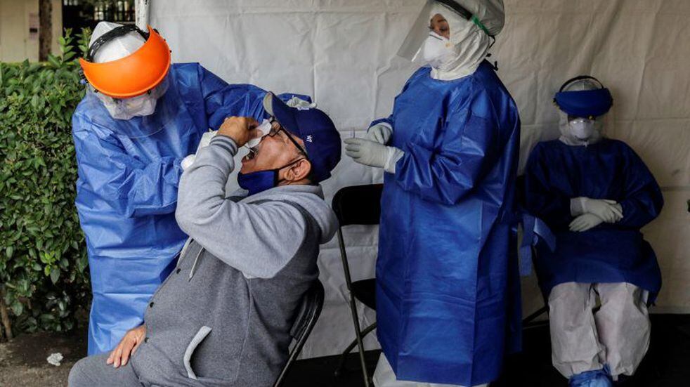 A healthcare worker wearing personal protective equipment (PPE) takes a swab sample from a man to be tested for the coronavirus disease (COVID-19) in Mexico City, Mexico November 6, 2020. REUTERS/Henry Romero