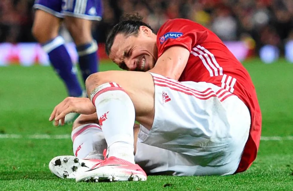 TOPSHOT - Manchester United's Swedish striker Zlatan Ibrahimovic reacts after falling awkwardly during the UEFA Europa League quarter-final second leg football match between Manchester United and Anderlecht at Old Trafford in Manchester, north west Englan