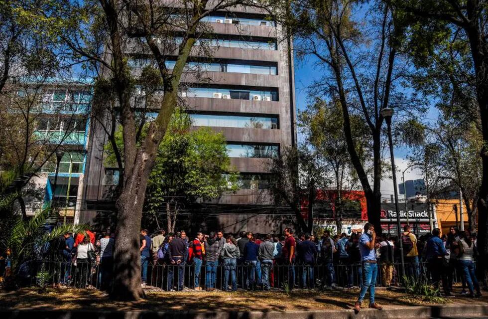 People wait on the streets after an earth tremor in Mexico City on February 1, 2019. (Photo by Rodrigo ARANGUA / AFP)