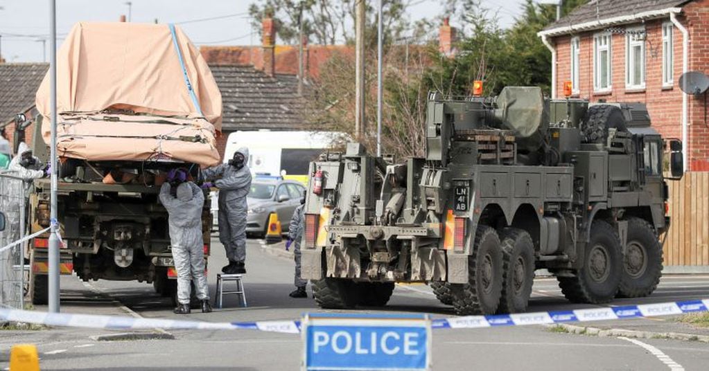 Soldiers wearing protective clothing  lift a tow truck in Hyde Road, Gillingham, Dorset, England as the investigation into the suspected nerve agent attack on Russian double agent Sergei Skripal continues Wednesday March 14, 2018.  The army cordoned off a road in Dorset on Wednesday as the investigated the attack on Sergei Skripal and his daughter Yulia. Authorities have cordoned off several sites in and near Salisbury, 90 miles (145 kilometers) southwest of London as part of their probe.  (Andrew Matthews/PA via AP)