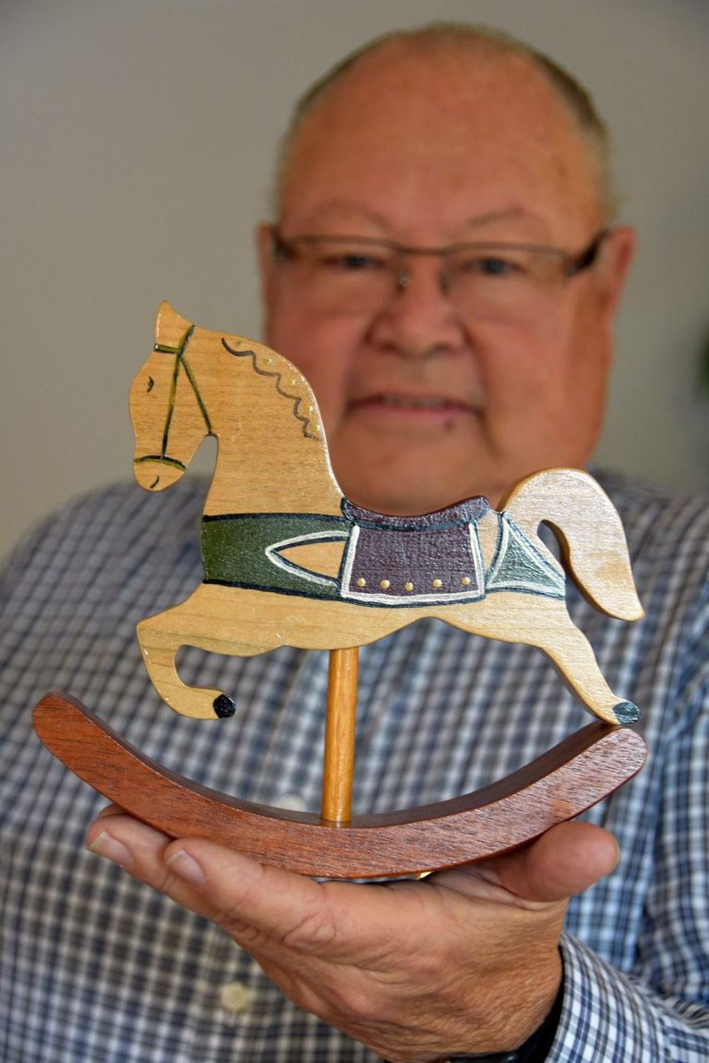 El miembro de la organización no lucrativa Orange County Woodworkers de California, José “Pepe” Ulloa, de 73 años, posa con un juguete de madera (EFE)