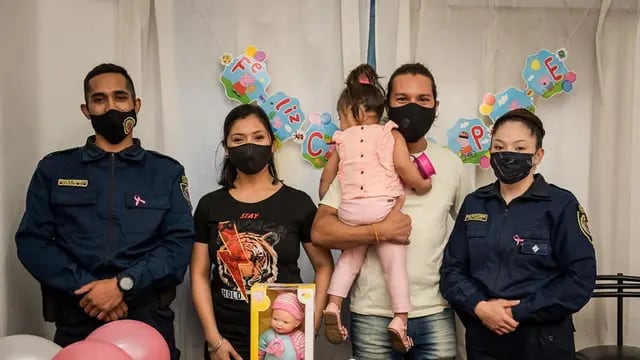 La oficial ayudante Brenda Sandoval y el Agente Alexis Papurello, junto a Ámbar y su familia. (Policía de Córdoba)