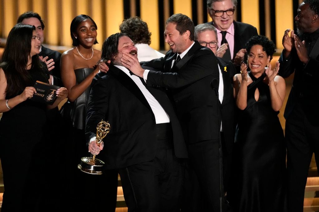 Matty Matheson, centro, y Ebon Moss-Bachrach se besan después de que "The Bear" ganara el premio a mejor comedia en la 75a edición de los Premios Emmy el lunes 15 de enero de 2024 en el Teatro Peacock de Los Ángeles. (Foto AP/Chris Pizzello)
