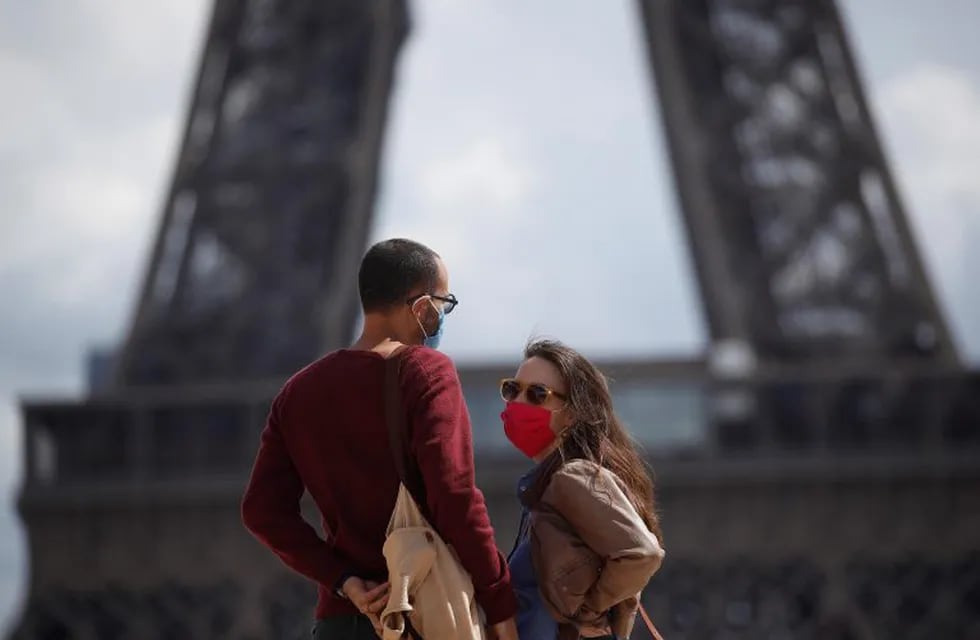 -FOTODELDÍA- EA5766. PARÍS (FRANCIA), 28/08/2020.- Una pareja ataviada con máscaras protectoras pasea cerca de la Torre Eiffel, este viernes en París (Francia), cuando el primer ministro del país, Jean Castex, ha anunciado la obligatoriedad de llevar máscara en la capital gala. EFE/ Yoan Valat