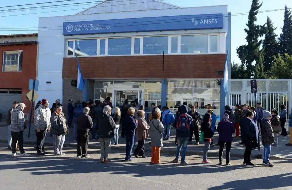 AME9940. EL ALTO (BOLIVIA), 03/04/2020.- Un policía boliviano revisa al ingreso al Banco de ciudadanos este viernes, en El Alto (Bolivia). Bolivia vive este viernes el primer día del cobro de bonos sociales específicos por la crisis de la COVID-19, lo que volvió a sacar a las calles a ancianos, el grupo más vulnerable de contagio, para hacer largas filas en los bancos en medio de una cuarentena. EFE/ Martin Alipaz