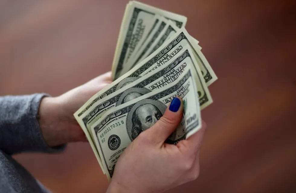 Una mujer cuenta billetes de dólar. (Foto: REUTERS/Marcos Brindicci)
