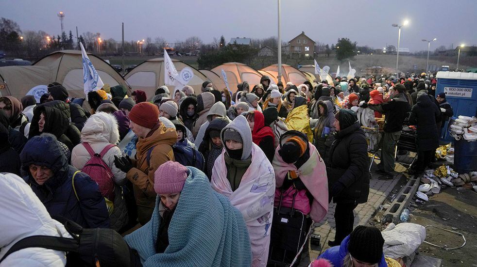 Los refugiados esperan en una multitud para el transporte después de huir de Ucrania y llegar al cruce fronterizo en Medyka, Polonia. (AP)