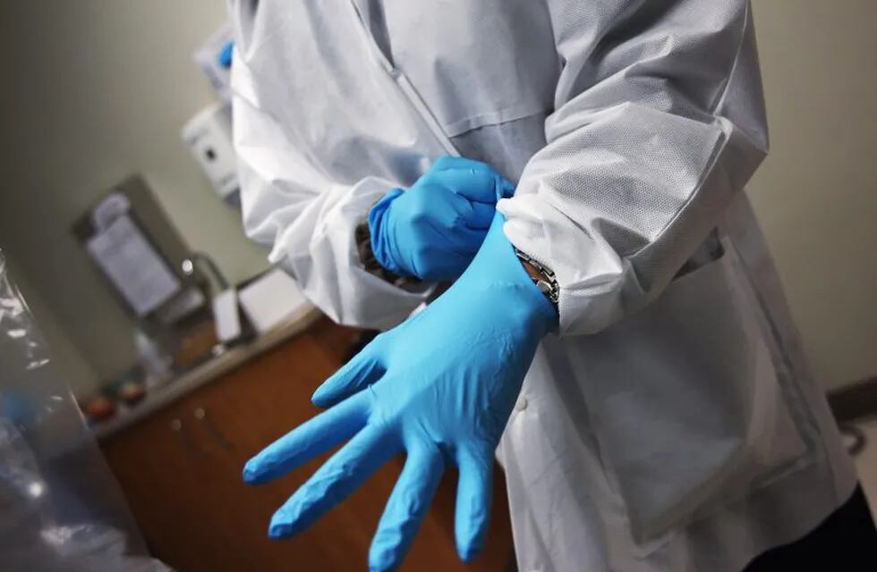 AURORA, CO - MARCH 27: A dentist dons sterile gloves at a community health center on March 27, 2012 in Aurora, Colorado. The center, called the Metro Community Provider Network, has received some 6,000 more Medicaid eligable patients since the healthcare reform law was passed in 2010. Expansion of such clinics nationwide is considered key to serving the millions more patients set to be be covered by Medicaid if the healthcare reform passes the current challenge in the Supreme Court. Preventative health services and treatments at community health centers are also designed to reduce emergency room expenditures, which are up to 10 times more costly.   John Moore/Getty Images/AFP== FOR NEWSPAPERS, INTERNET, TELCOS & TELEVISION USE ONLY ==\r\n eeuu colorado  dentista dentistas