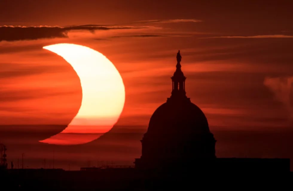 Eclipse solar parcial cuando el sol sale a la izquierda del edificio del Capitolio de los Estados Unidos, el 10 de junio de 2021