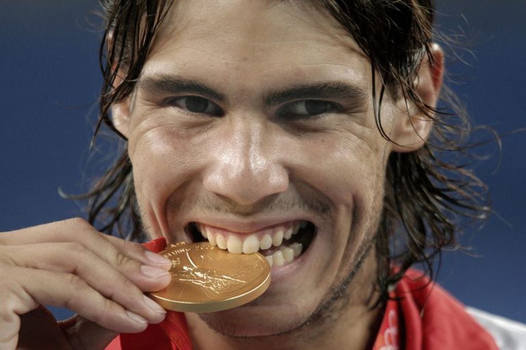 Rafael Nadal, uno de los seguidores más fieles de esta tradición, muerde su medalla en Pekín, 2008. (EFE).