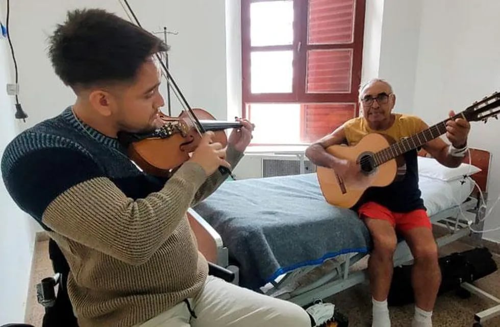 El nieto y el abuelo en el Hospital de Clínicas, tocando folclore. (Gentileza Fredy Bustos, El Doce TV)