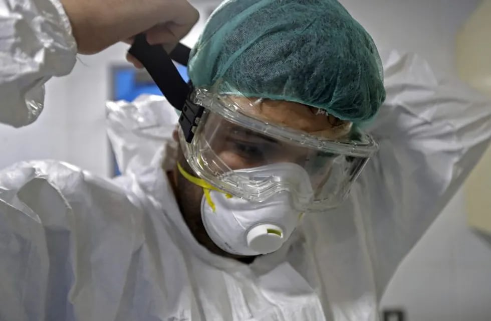 A doctor wears his protective gear ahead of seeing a patient suffering from coronavirus disease (COVID-19) in an isolated intensive care unit at the Rafik Hariri public hospital in the Lebanese capital Beirut on April 7, 2020. - The Mediterranean country announced a lockdown and closed its airport as of March 19 as part of measures to curb the spread of COVID-19, which has officially infected 548 people and killed 18 nationwide. (Photo by JOSEPH EID / AFP)