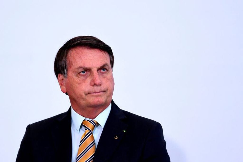 Brazilian President Jair Bolsonaro gestures during the launch of a program for the resumption of tourism, a sector severely affected by the new coronavirus outbreak, at Planalto Palace in Brasilia, on November 10, 2020. - Brazil's decision to halt trials of a Chinese-developed Covid-19 vaccine triggered a politically charged row Tuesday as a top health official expressed "indignation" and far-right President Jair Bolsonaro claimed the ruling as a personal victory. (Photo by EVARISTO SA / AFP)