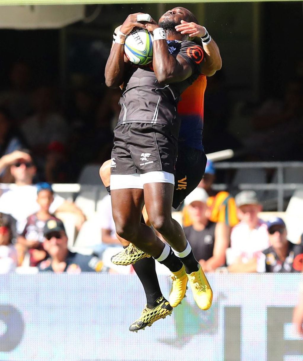Sbu Nkosi salta ante la defensa de un jugador argentino (Foto: ANESH DEBIKY / AFP)