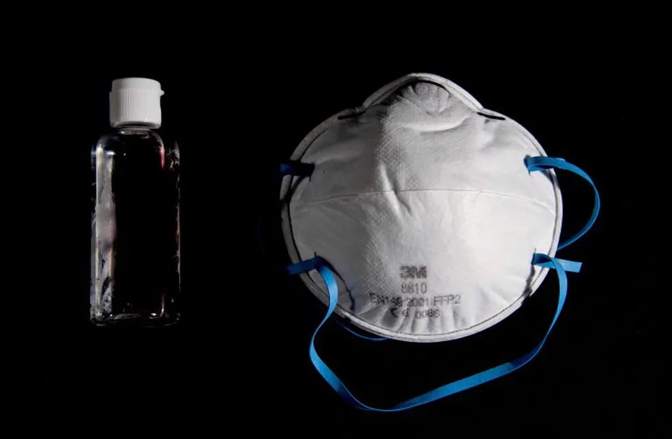 A picture taken on March 4, 2020, in Paris, shows a bottle of alcohol gel hand sanitiser and an FFP2 protective face mask. - Sales of face masks and hand sanitiser have risen and shortages are occuring in countries affected by the spread of COVID-19, the new coronavirus. (Photo by Olivier MORIN / AFP)