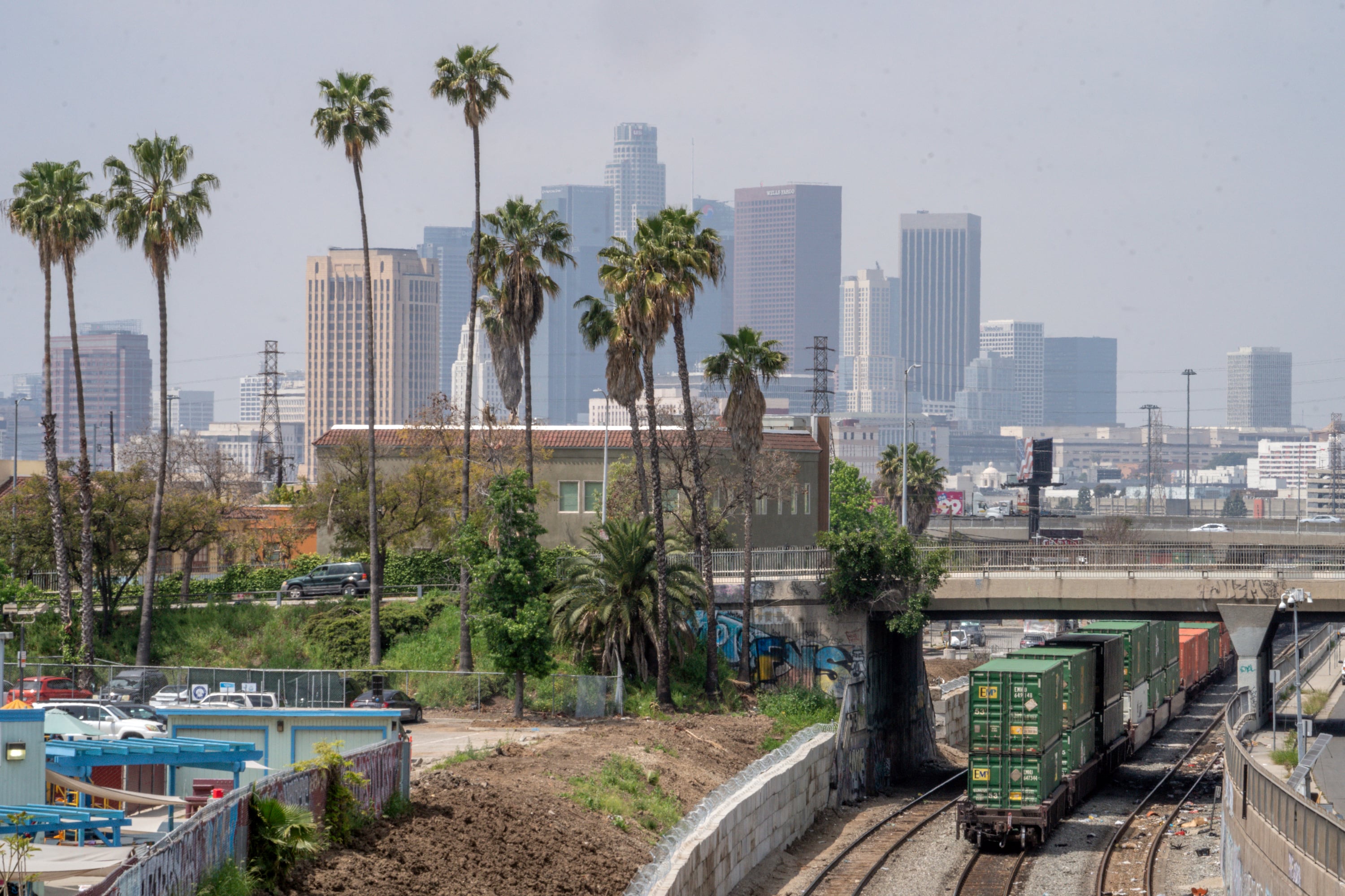 La ciudad de Los Ángeles detrás de un tren que pasa por la terminal de Union Pacific LATC Intermodal el martes 25 de abril de 2023, en Los Ángeles, California. (AP Foto/Damian Dovarganes)