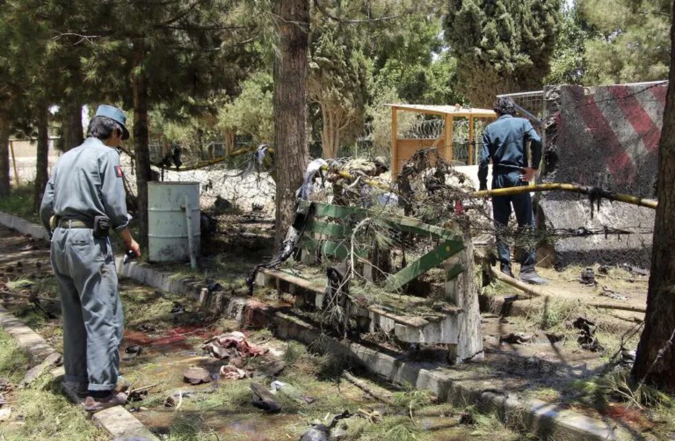 HMD02 HELMAND (AFGANISTÁN), 22/06/2017.- Agentes de seguridad afganos inspeccionan el lugar donde se produjo un atentado suicida con un coche cargado de explosivos en la entrada de una sucursal bancaria, en Lashkargh, provincia de Helmand, Afganistán, hoy, 22 de junio de 2017. Al menos 20 personas murieron, en su mayoría civiles, y otras 55 resultaron heridas en el ataque. EFE/WATAN YAR