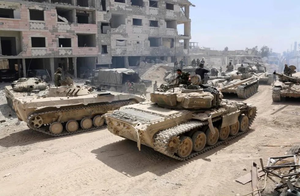 A picture taken on April 8, 2018, shows Syrian Army soldiers gathering in an area on the eastern outskirts of Douma, as they continue their fierce offensive to retake the last opposition holdout in Eastern Ghouta.\nThe Syrian government unleashed a ferocious assault on the then-rebel stronghold of Eastern Ghouta on February 18, aiming to crush Islamist and jihadist groups on the doorstep of the capital. / AFP PHOTO / STRINGER