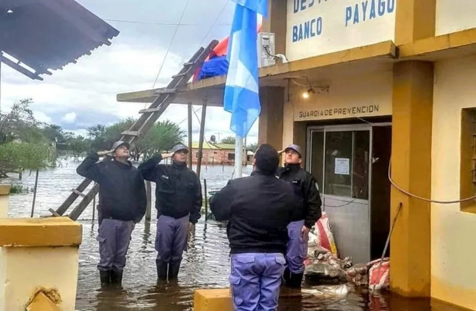 Policía de Banco Payaguá izando las banderas en medio del agua