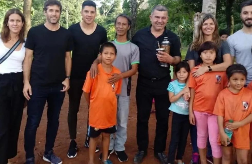 Nacho Scocco y Enzo Pérez con chicos de la aldea guaraní de Iguazú donde River financió un polideportivo. (El Territorio)
