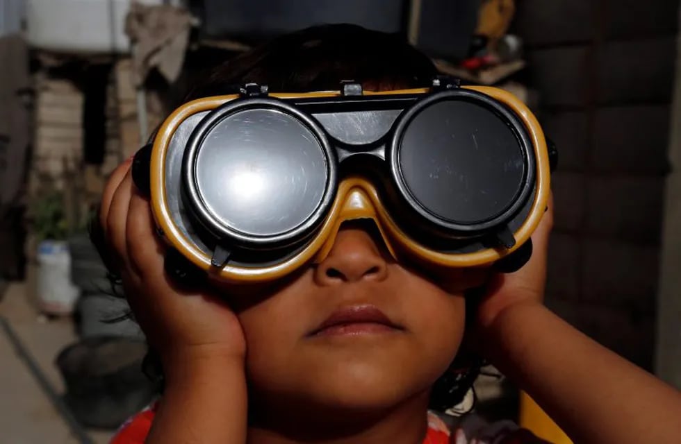 -FOTODELDIA- Sanaa (Yemen), 21/06/2020.- Un niño usa anteojos protectores especiales para observar un eclipse solar parcial en Sanaa, Yemen, 21 de junio de 2020. Un eclipse solar parcial ocurre cuando una porción de la Tierra está envuelta por la sombra ( penumbra) proyectada por la Luna cuando pasa entre nuestro planeta y el Sol en una alineación imperfecta. EFE / YAHYA ARHAB