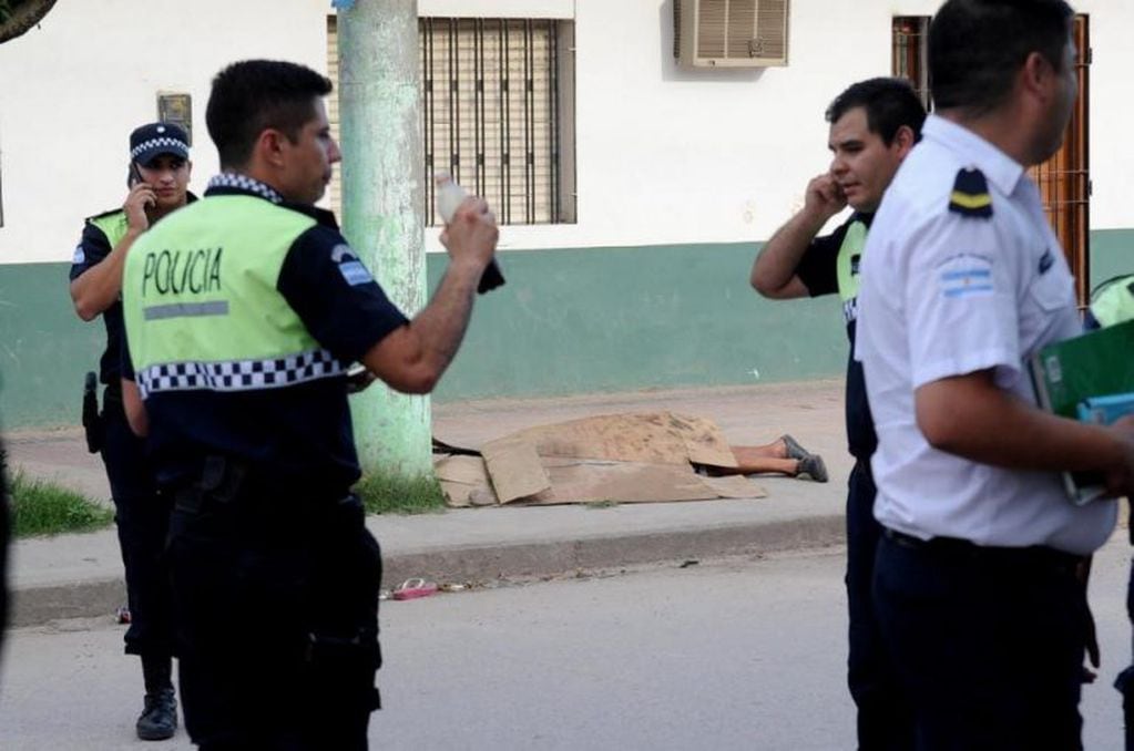 La policía espera instrucciones, mientras Gómez se encuentra muerto en la vereda.