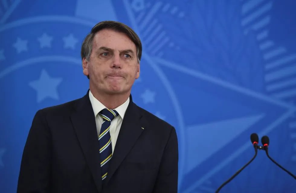 Brazil's President Jair Bolsonaro speaks to journalists about the new coronavirus at Planalto presidential palace in Brasilia, Brazil, Friday, March 27, 2020. Even as coronavirus cases mount in Latin America’s largest nation, Bolsonaro is calling the pandemic a momentary, minor problem and saying strong measures to contain it are unnecessary. (AP Photo/Andre Borges)