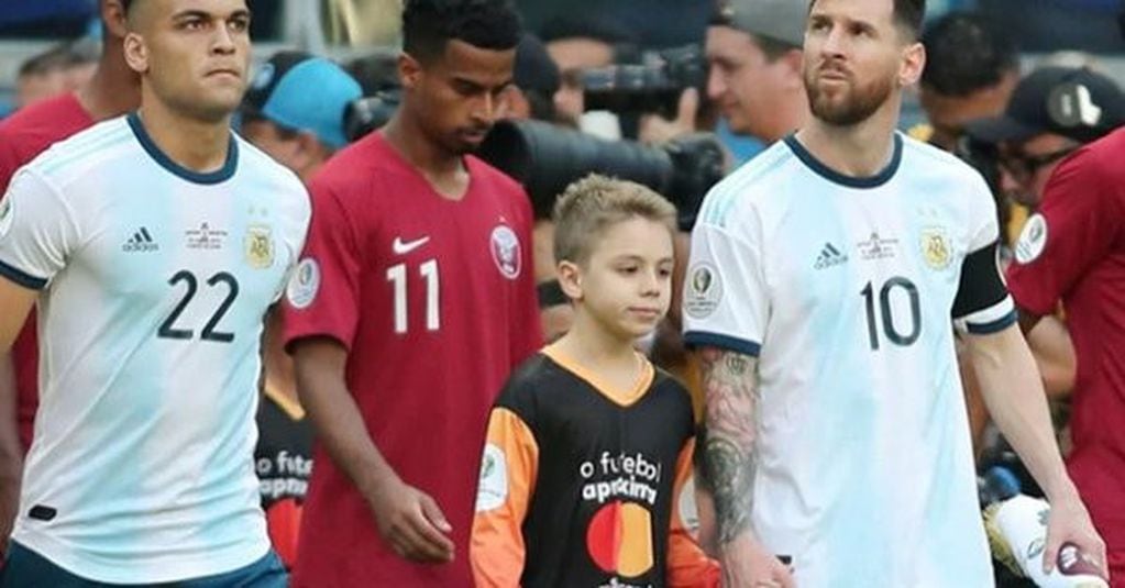 Lionel Messi junto a Tomás Chávez, el niño misionero que lo acompañó en la salida al Arena do Gremio para enfrentar a Catar por la Copa América de Brasil.