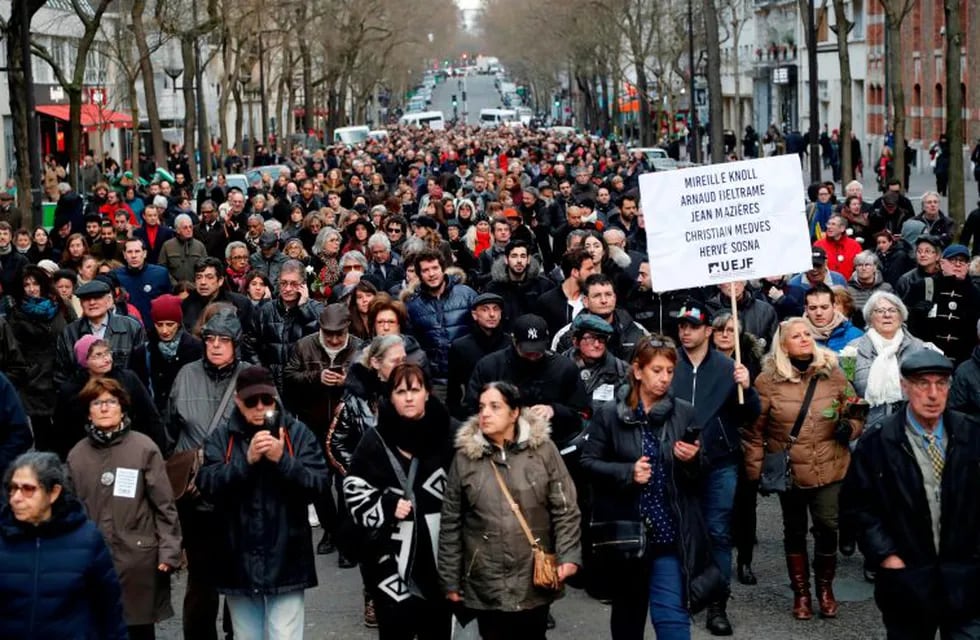 Participants walk holding placards during a silent march in Paris on March 28, 2018, in memory of Mireille Knoll, an 85-year-old Jewish woman murdered in her home in what police believe was an anti-Semitic attack.\nThe partly burned body of Mireille Knoll, who escaped the mass deportation of Jews from Paris during World War II, was found in her small apartment in the east of the city on March 23, by firefighters called to extinguish a blaze. / AFP PHOTO / FRANCOIS GUILLOT