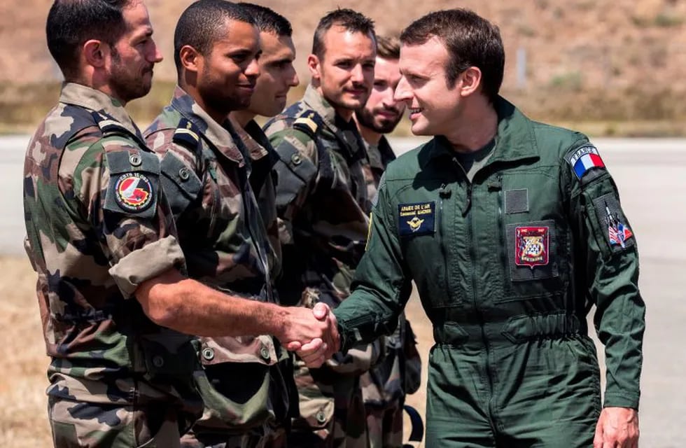(FILES) This file photo taken on July 20, 2017 shows French President Emmanuel Macron (R) meeting with troops during a visit to the French air force base BA 125 in Istres, southeastern France.\r\nFrench President Emmanuel Macron has for the first time ordered overnight on April 14, 2018 a major military operation by deciding to conduct joint strikes, along with the US and Britain, against the Syrian regime of Bashar al-Assad in response to alleged chemical weapons attacks. / AFP PHOTO / POOL / Arnold JEROCKI francia Emmanuel Macron presidente de francia visita tropas base militar en istres