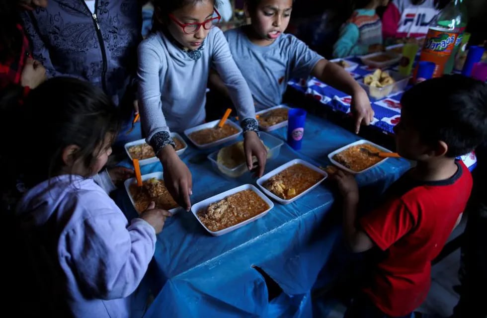 Childs prepare to eat stew at a soup kitchen in Claypole, on the outskirts of Buenos Aires, Argentina September 17, 2019. Picture taken September 17, 2019. REUTERS/Agustin Marcarian   chicos niños  desnutricion pobreza hambre emergencia alimentaria  comederos comedor  merenderos merendero