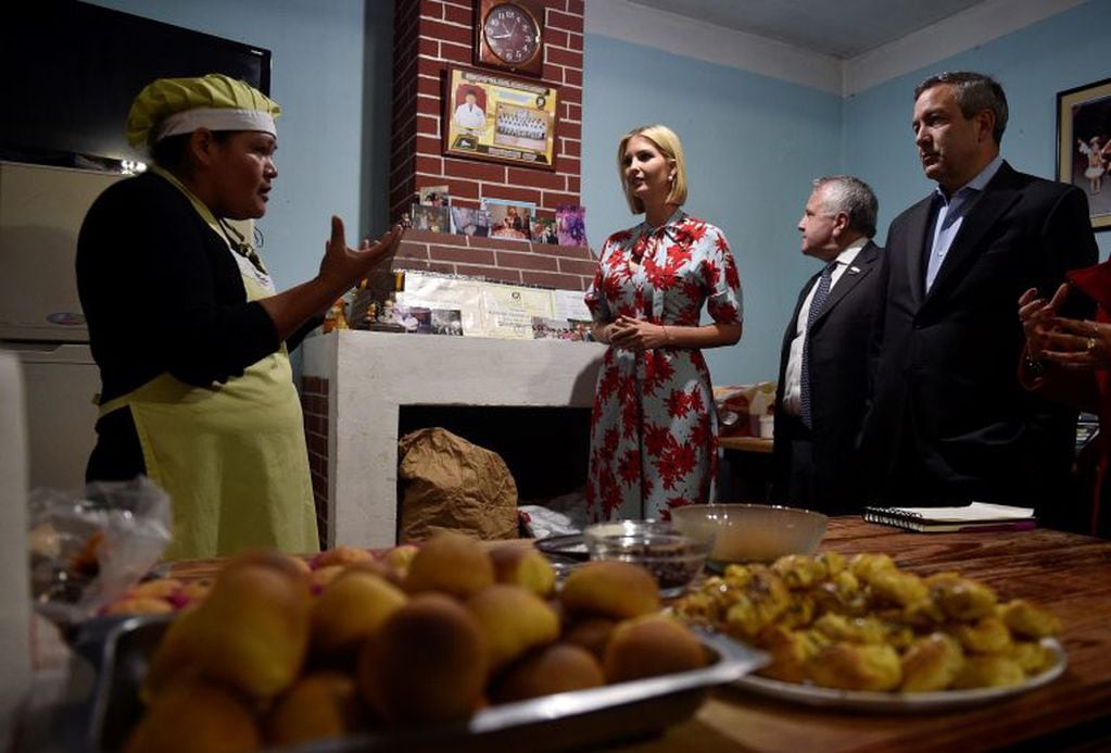 Trump escucha con atención a la propietaria de la panadería, Cristina Alcocer, explicar cómo realiza sus labores cotidianas. (AP Photo/Gustavo Garello)