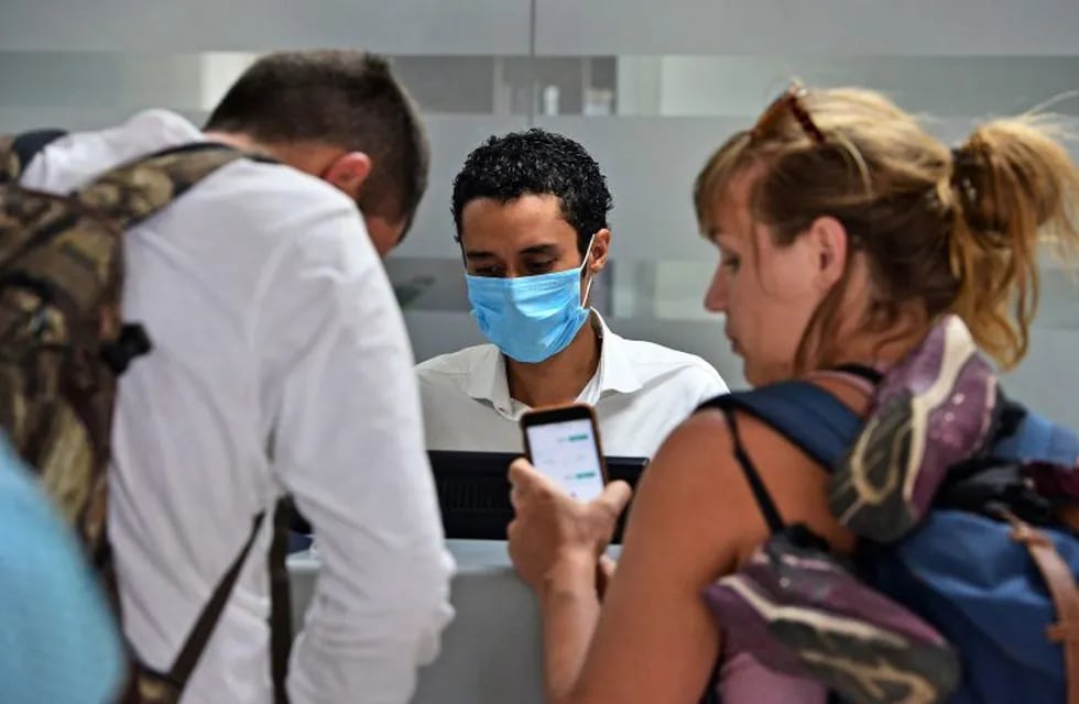 An airline employee wears a protective face mask as a precaution against the spread of the new Coronavirus, COVID-19, at Toncontin International Airport, in Tegucigalpa, on March 6, 2020. - Honduran Government has intensified the security on the borders and airports to prevent an eventual propagation of the new Coronavirus, COVID-19. (Photo by ORLANDO SIERRA / AFP)